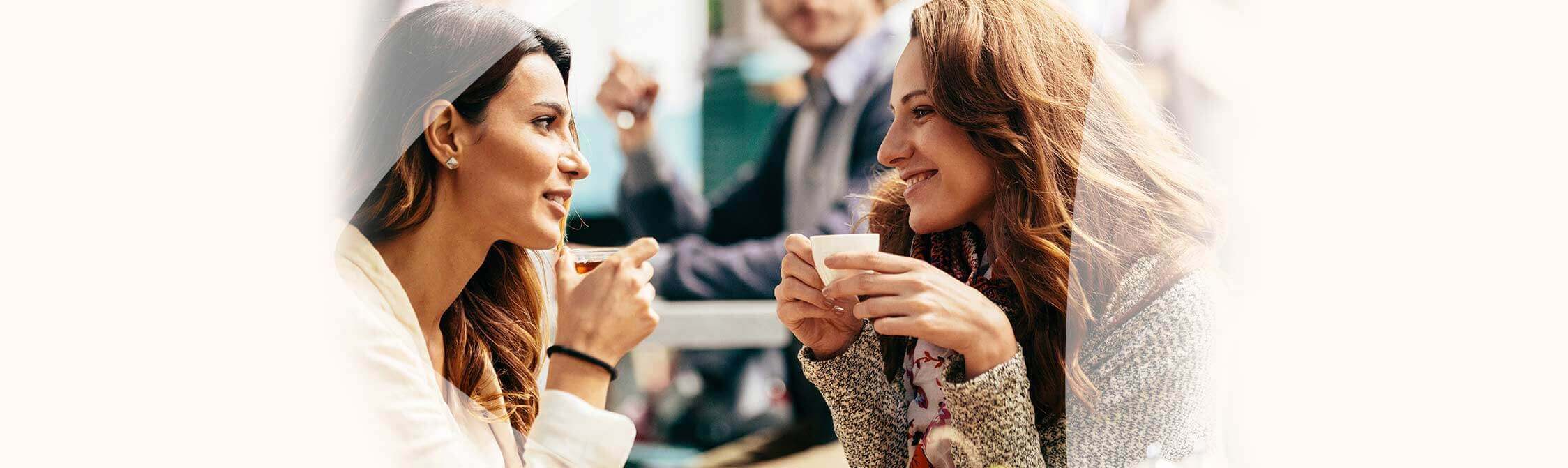 Twee vriendinnen in gesprek op café