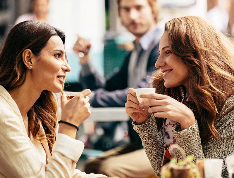 Twee vriendinnen in gesprek op café
